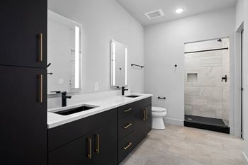 A bathroom with black cabinets and white countertops